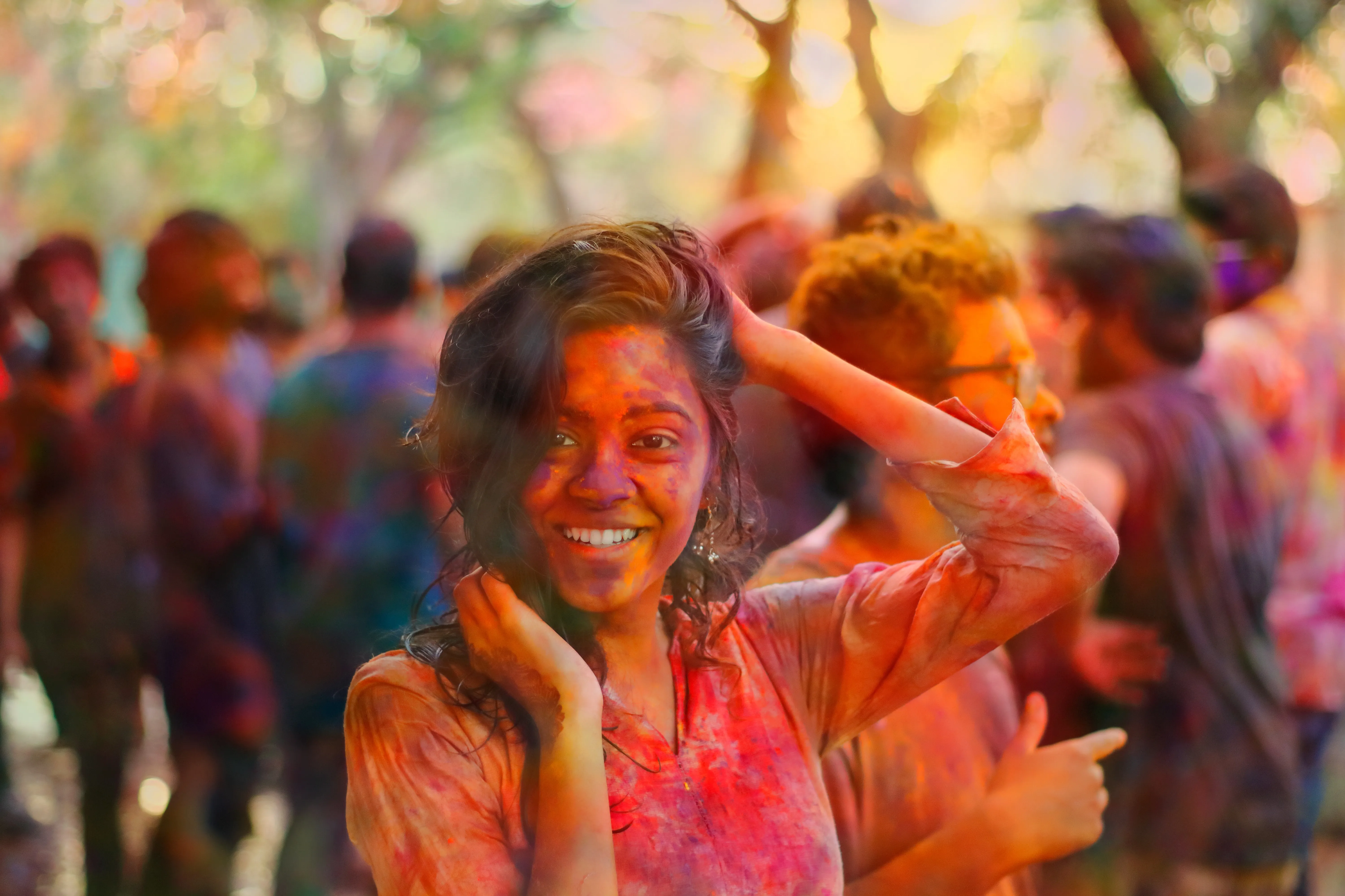A Woman Celebrating Holi with Colourful Joy Free Wallpaper