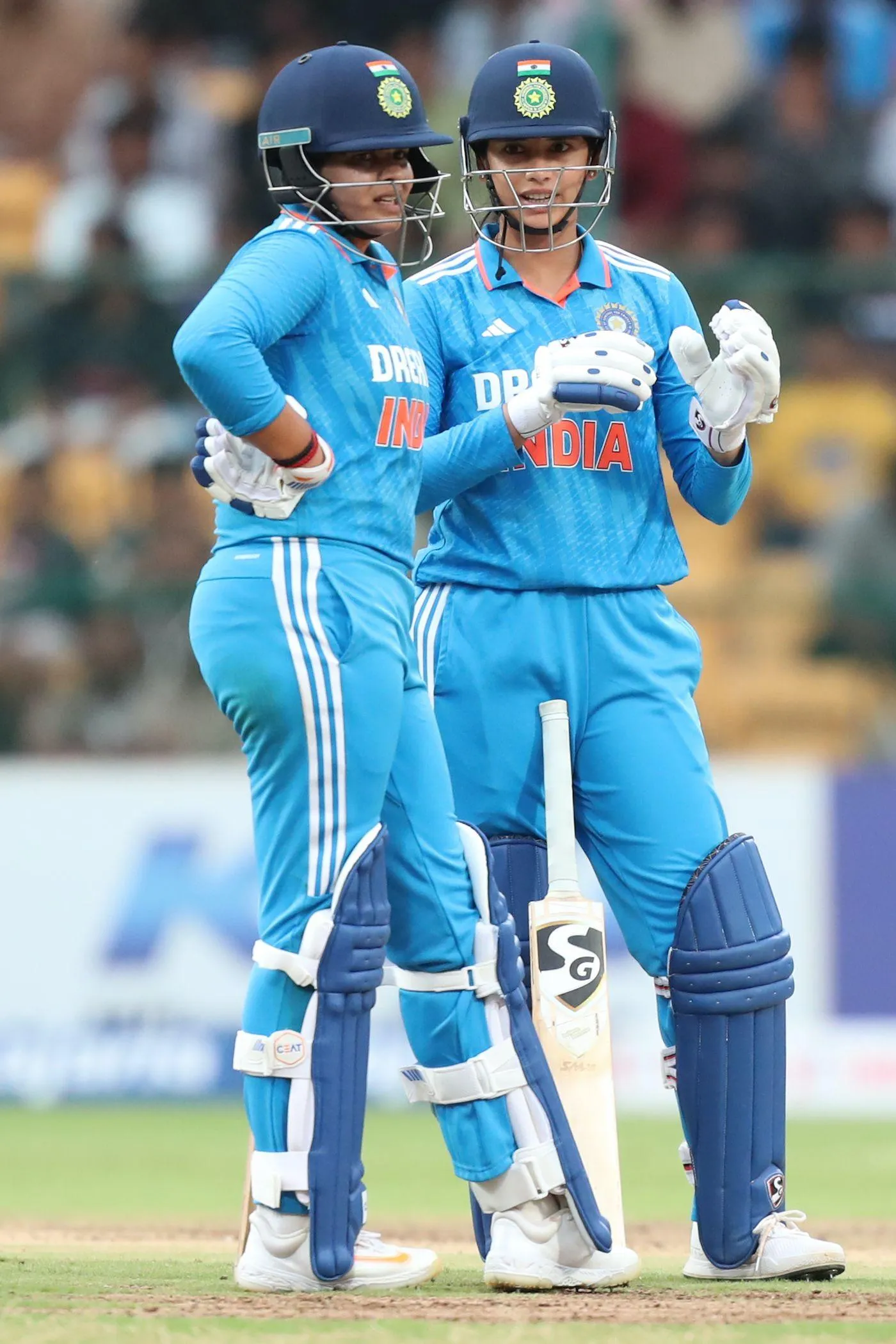 Smriti celebrating with team in blue cricket uniform