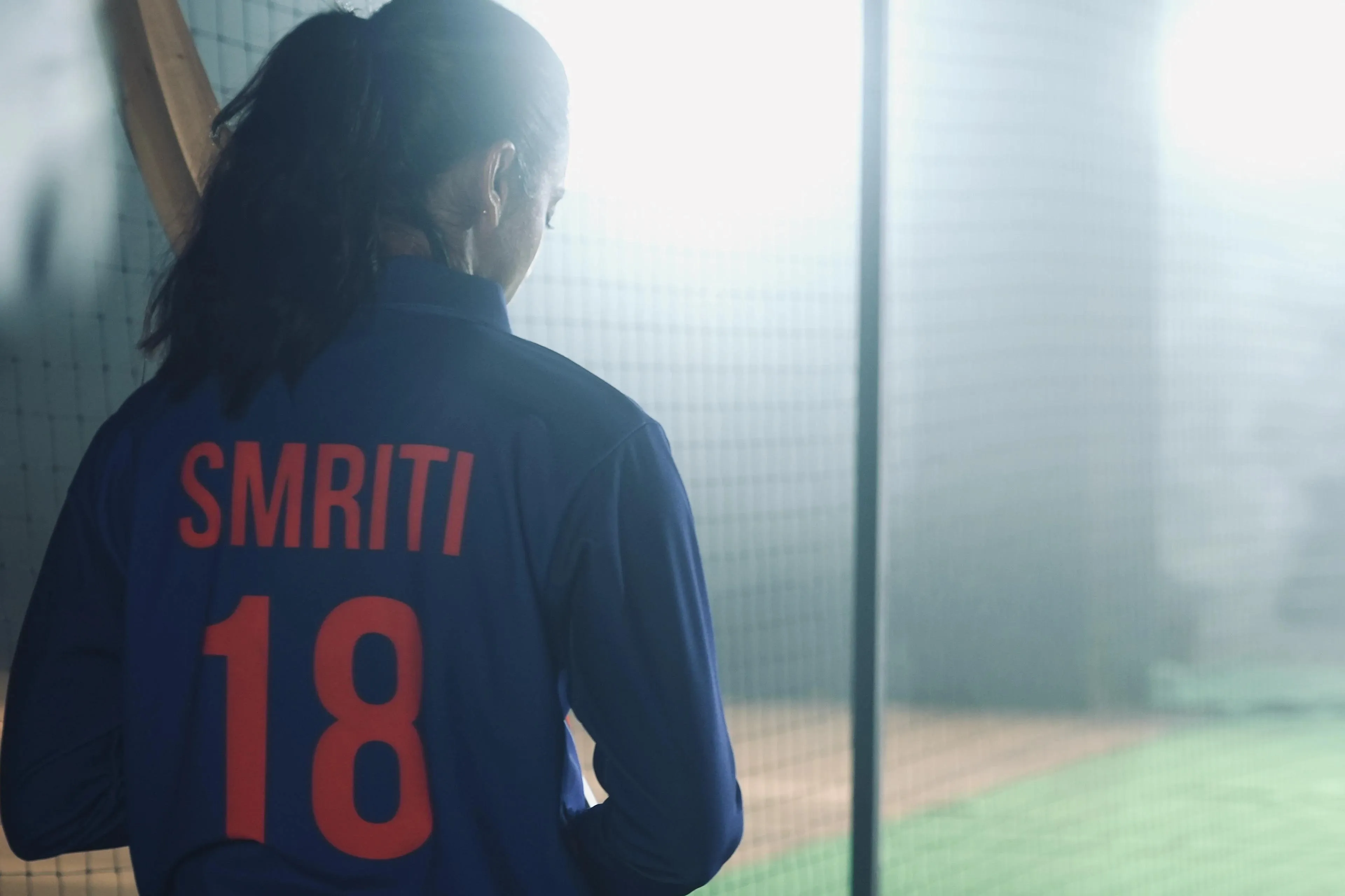 Smriti in jersey number 18 looking out at the sunlight