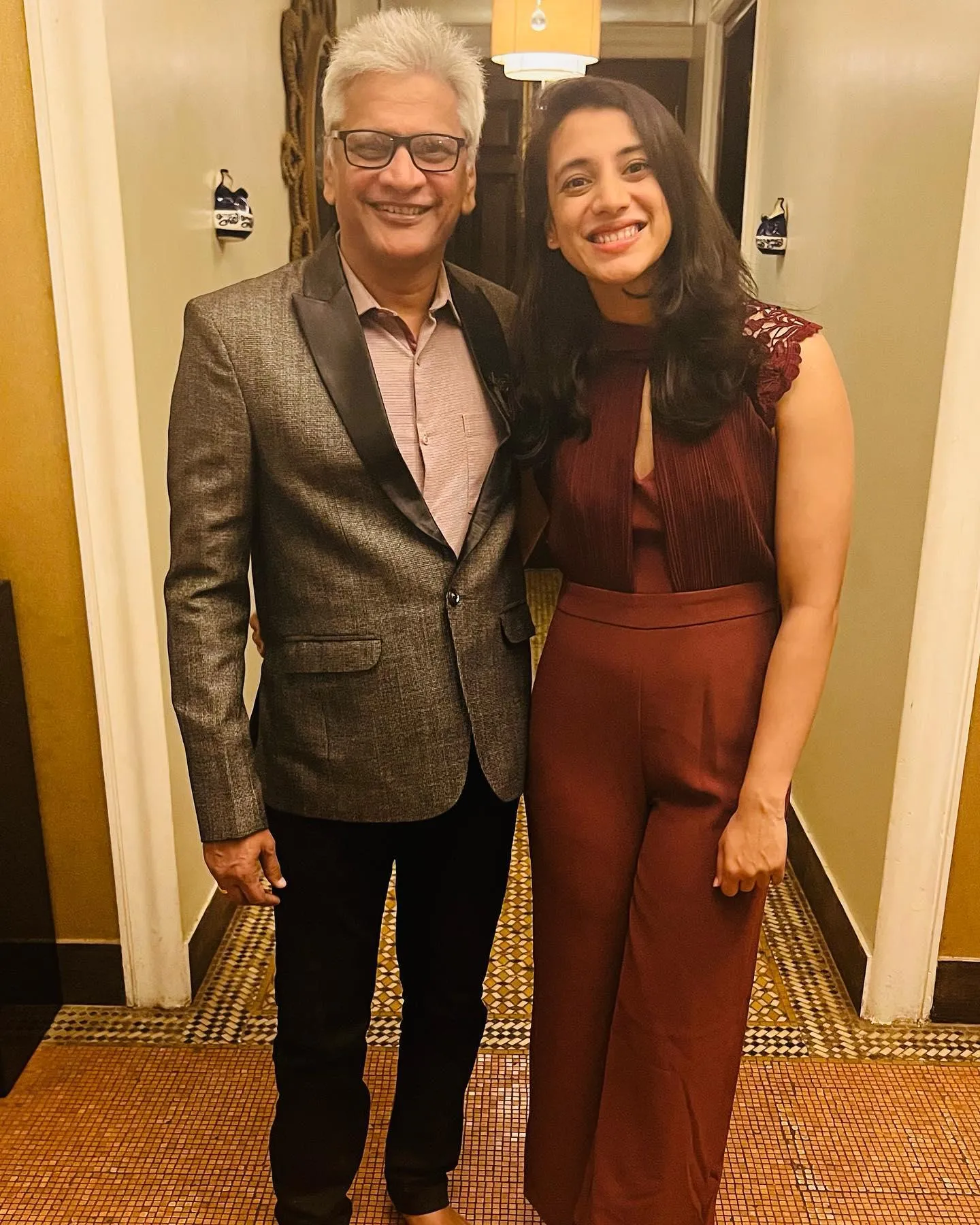 Smriti Mandhana and friend smiling indoors in casual wear