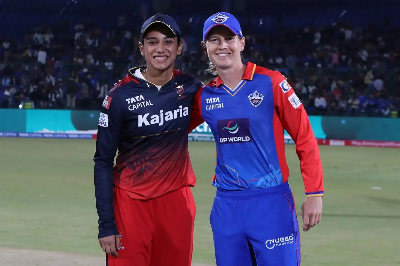 Smriti Mandhana and teammate smiling during a cricket match