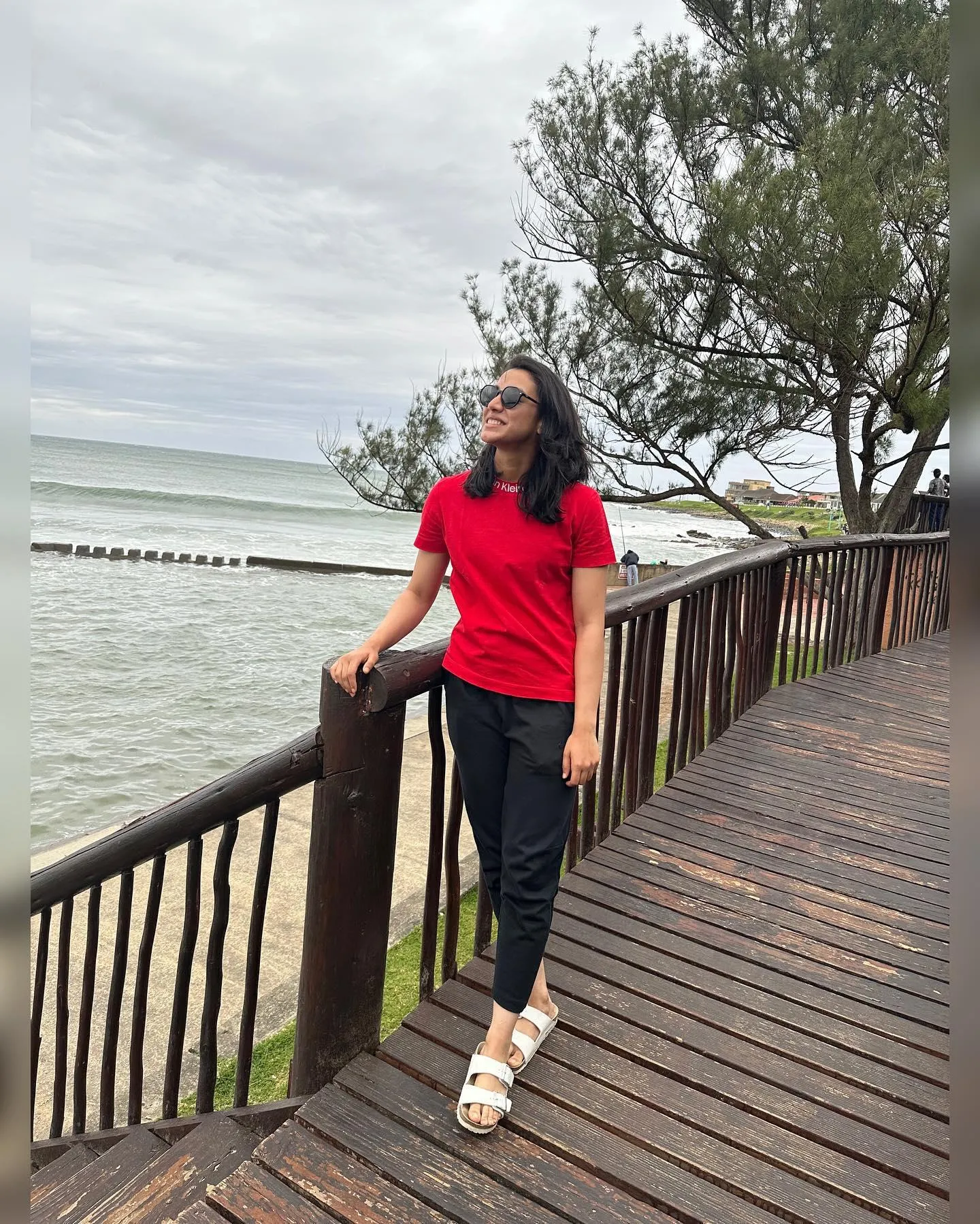 Smriti Mandhana by Ocean Leaning on Wooden Rail wallpaper