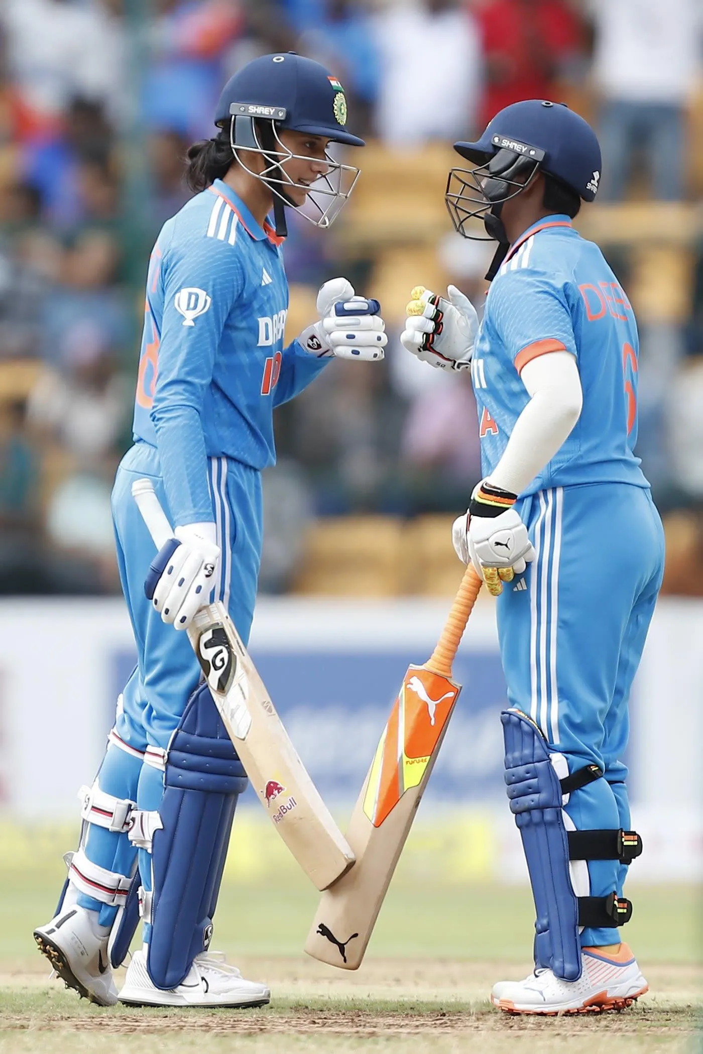 Smriti Mandhana celebrating with a teammate cricket field