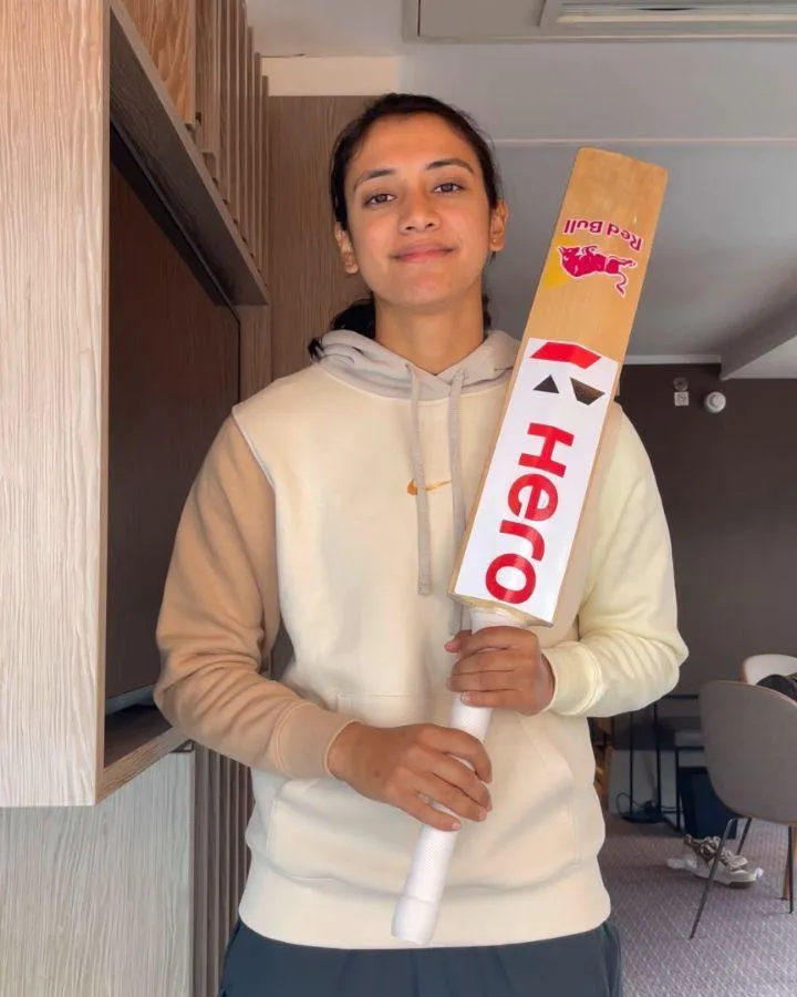 Smriti Mandhana holding a cricket bat at home wallpaper