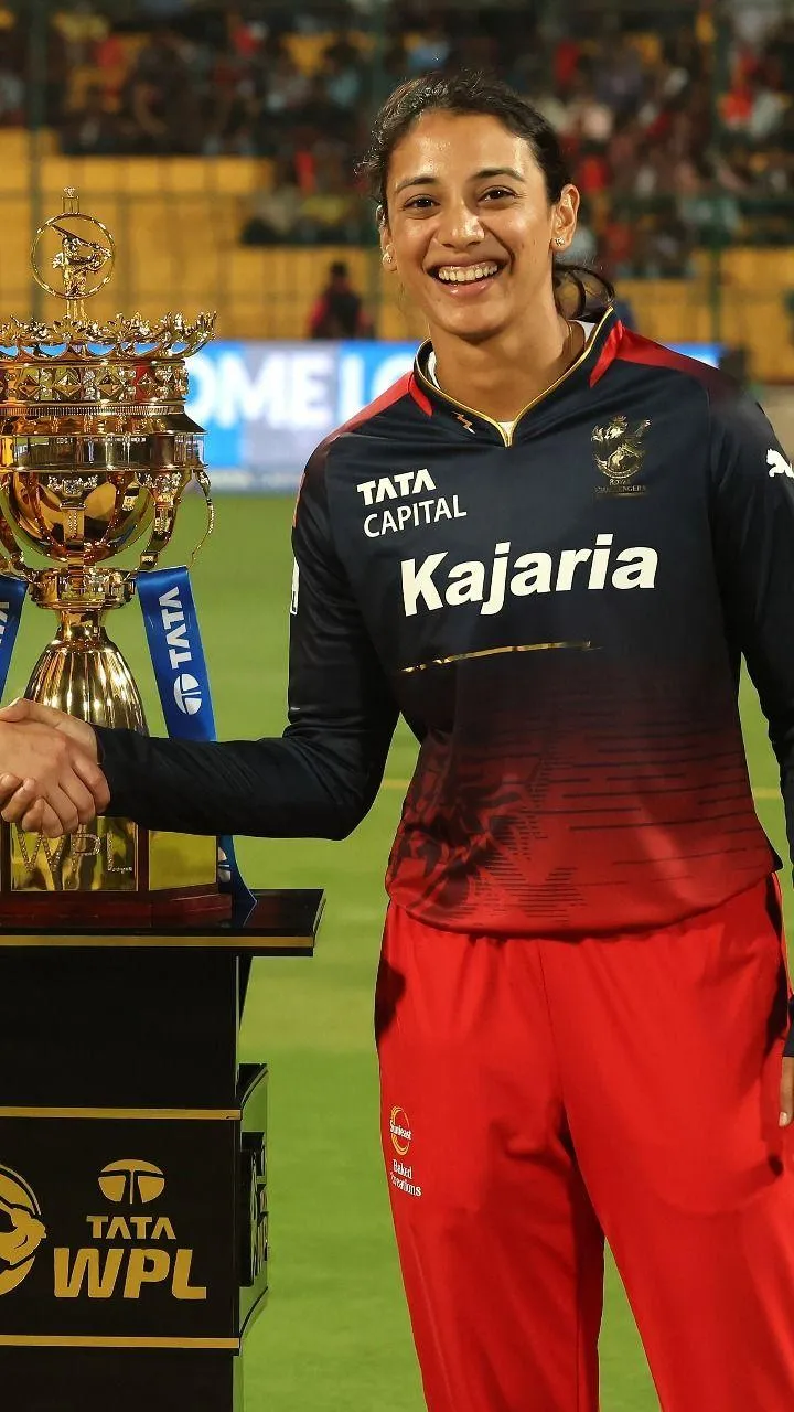 Smriti Mandhana holding a trophy celebrating her success