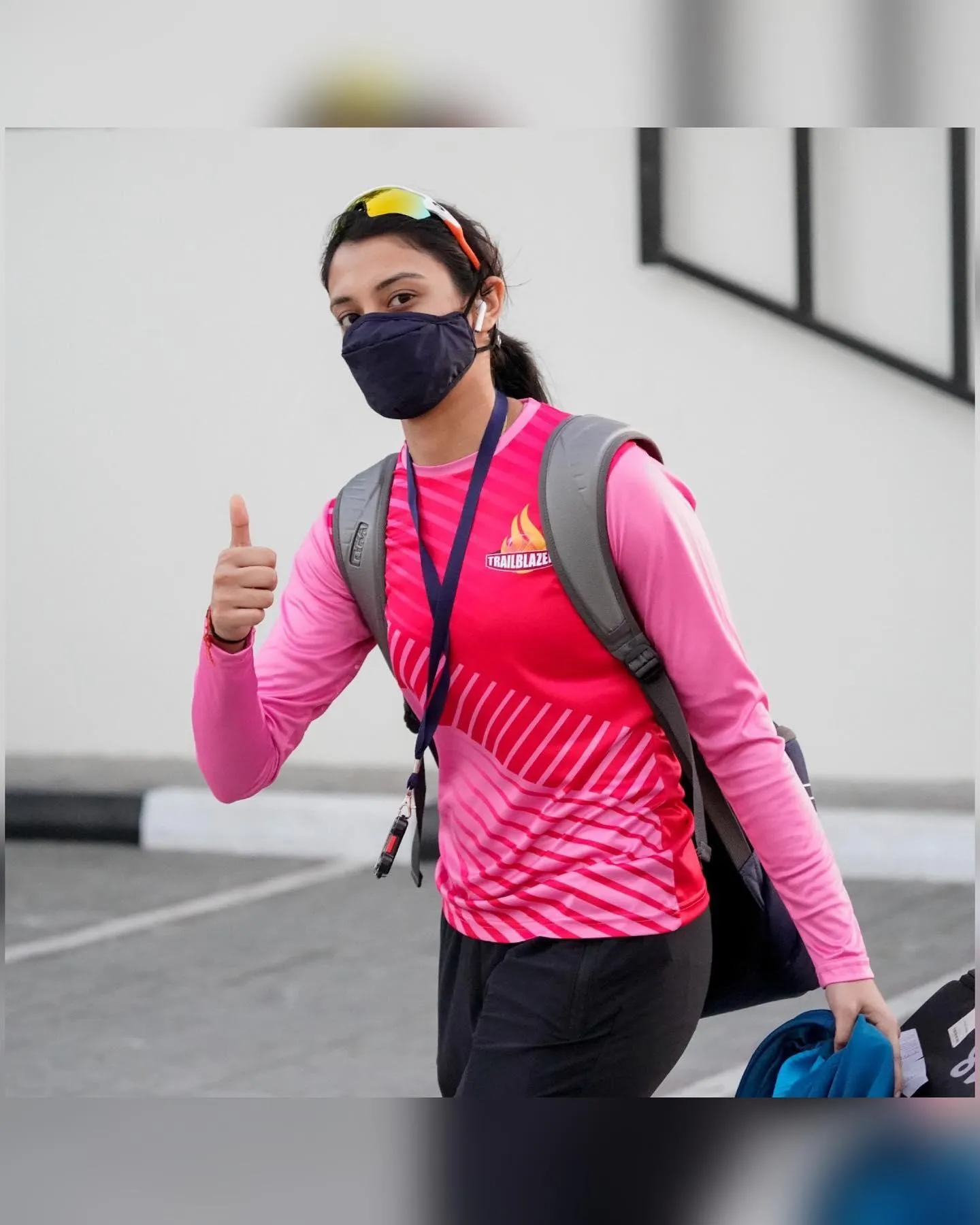 Smriti Mandhana in a pink jacket practicing cricket