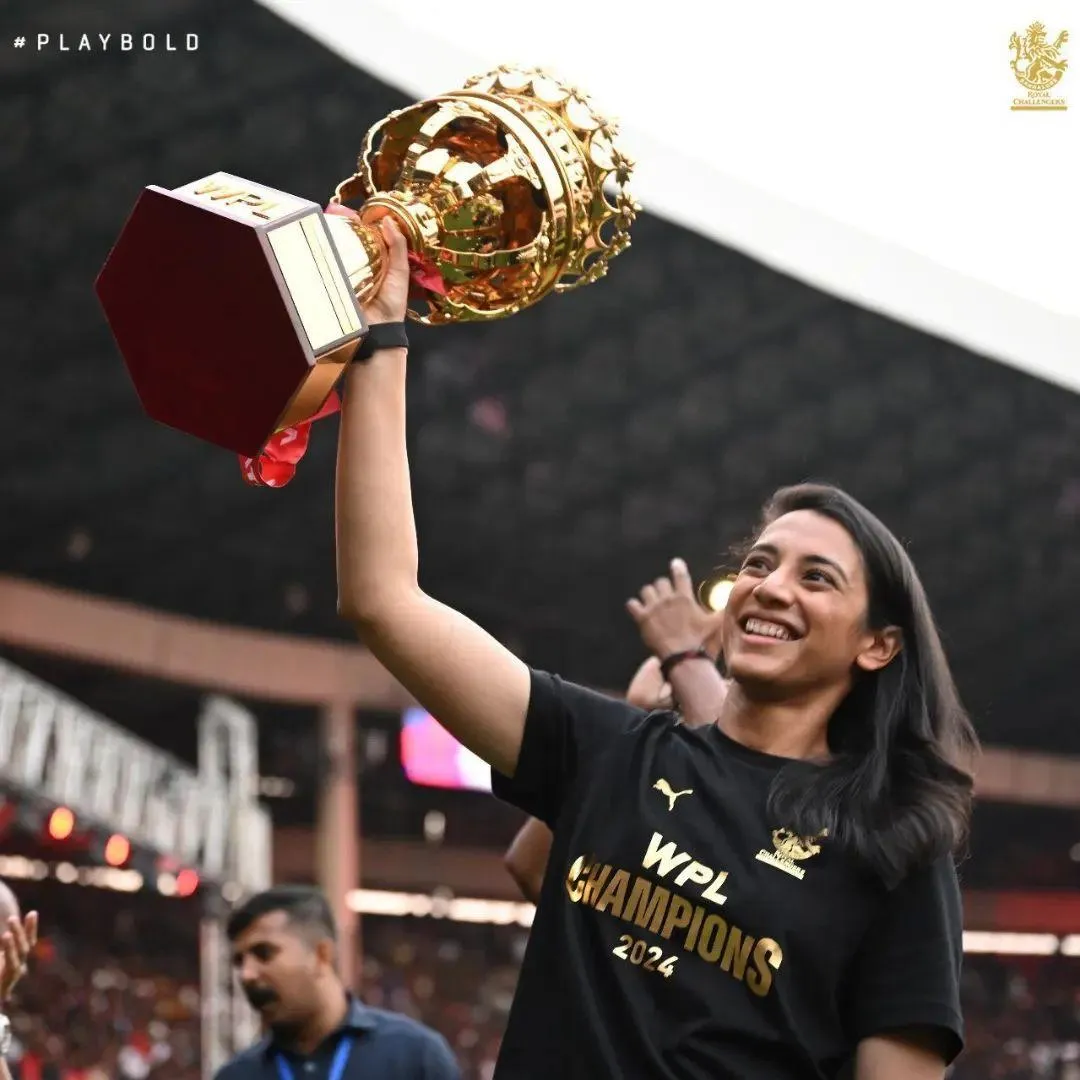 Smriti Mandhana in a victory pose team championship trophy