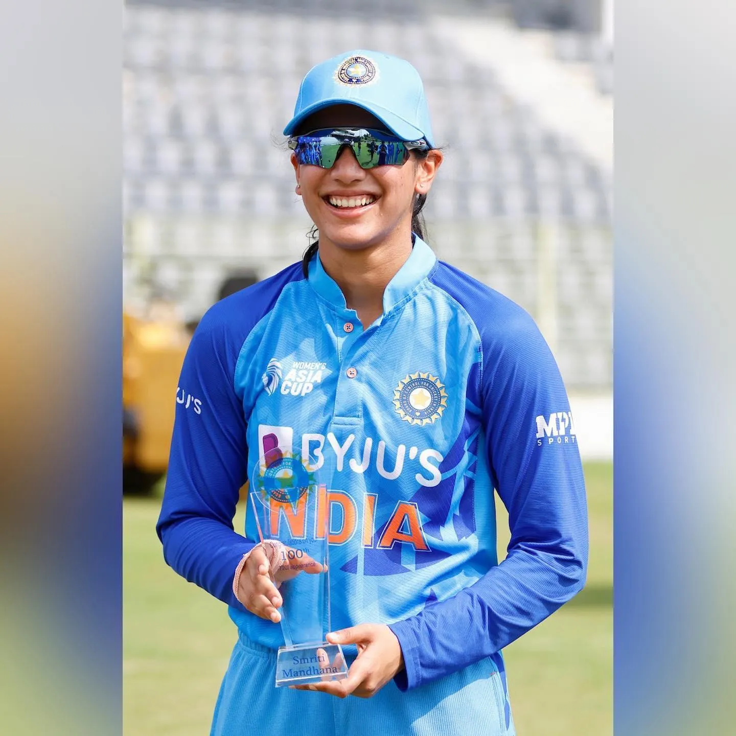 Smriti Mandhana lifting a trophy celebrating victory