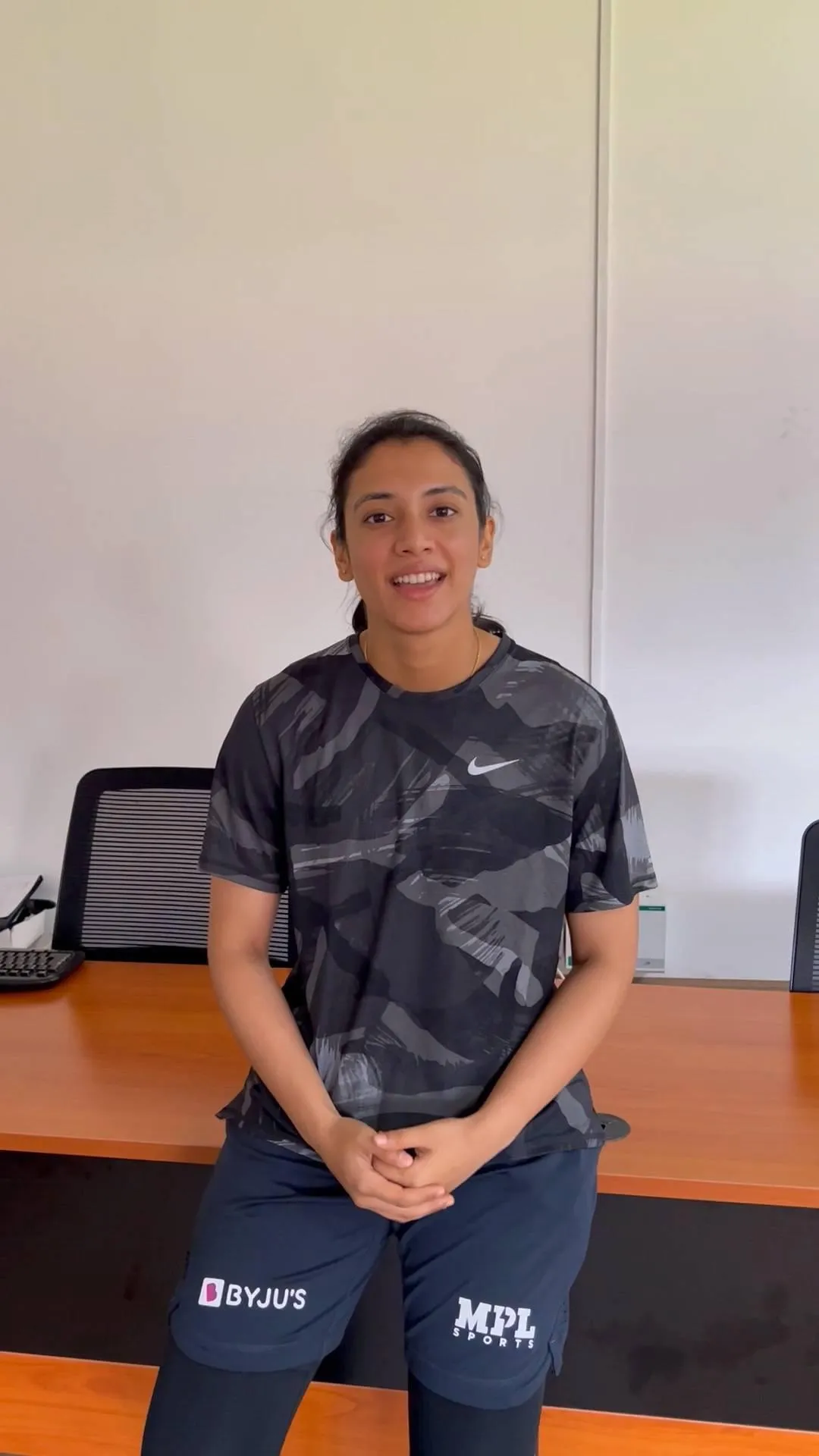 Smriti Mandhana posing casually against a plain white backdrop