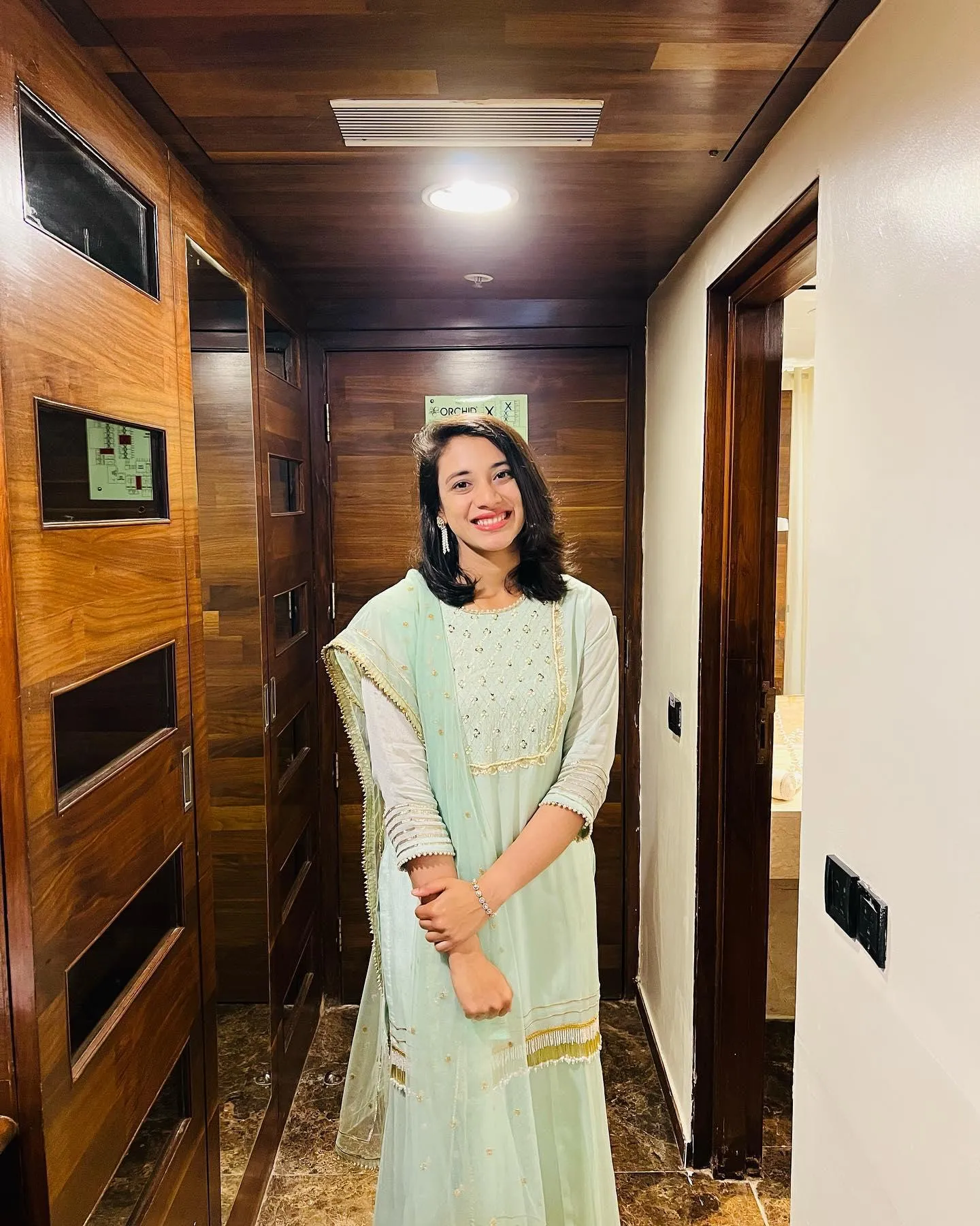 Smriti Mandhana posing confidently in hallway lighting