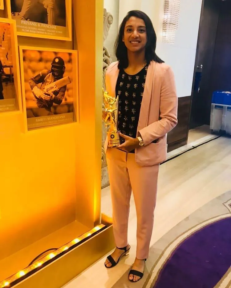 Smriti Mandhana posing in formal dress at indoor event
