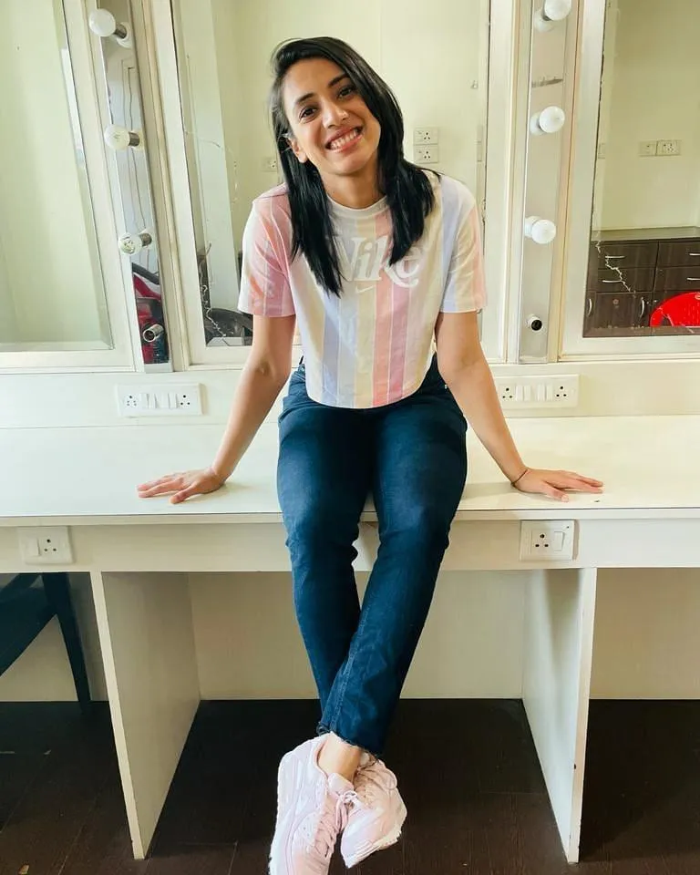 Smriti Mandhana posing in jeans and white shirt indoors