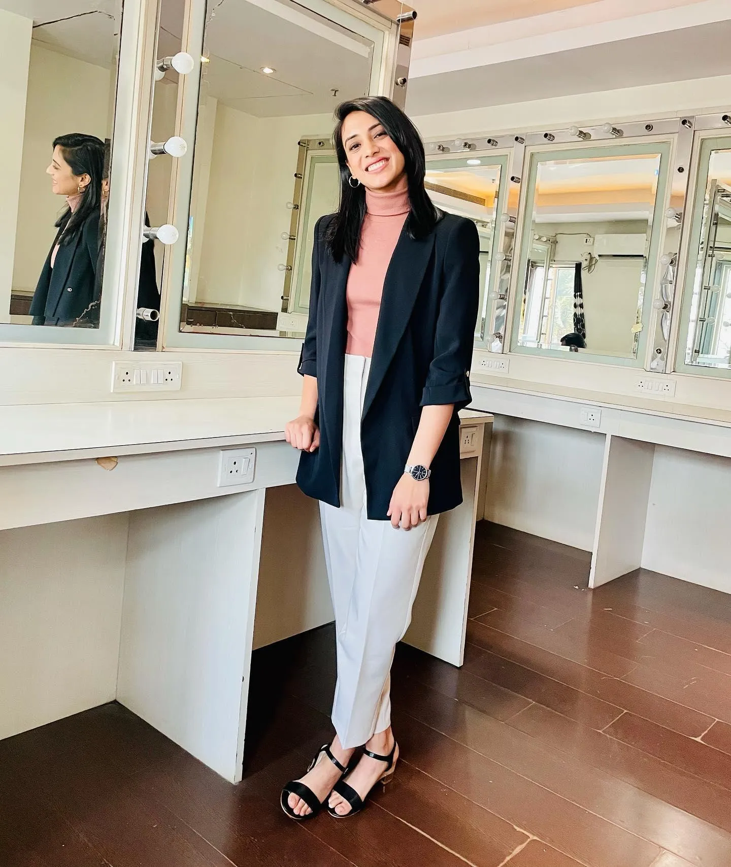 Smriti Mandhana posing indoors wearing casual jacket and pants