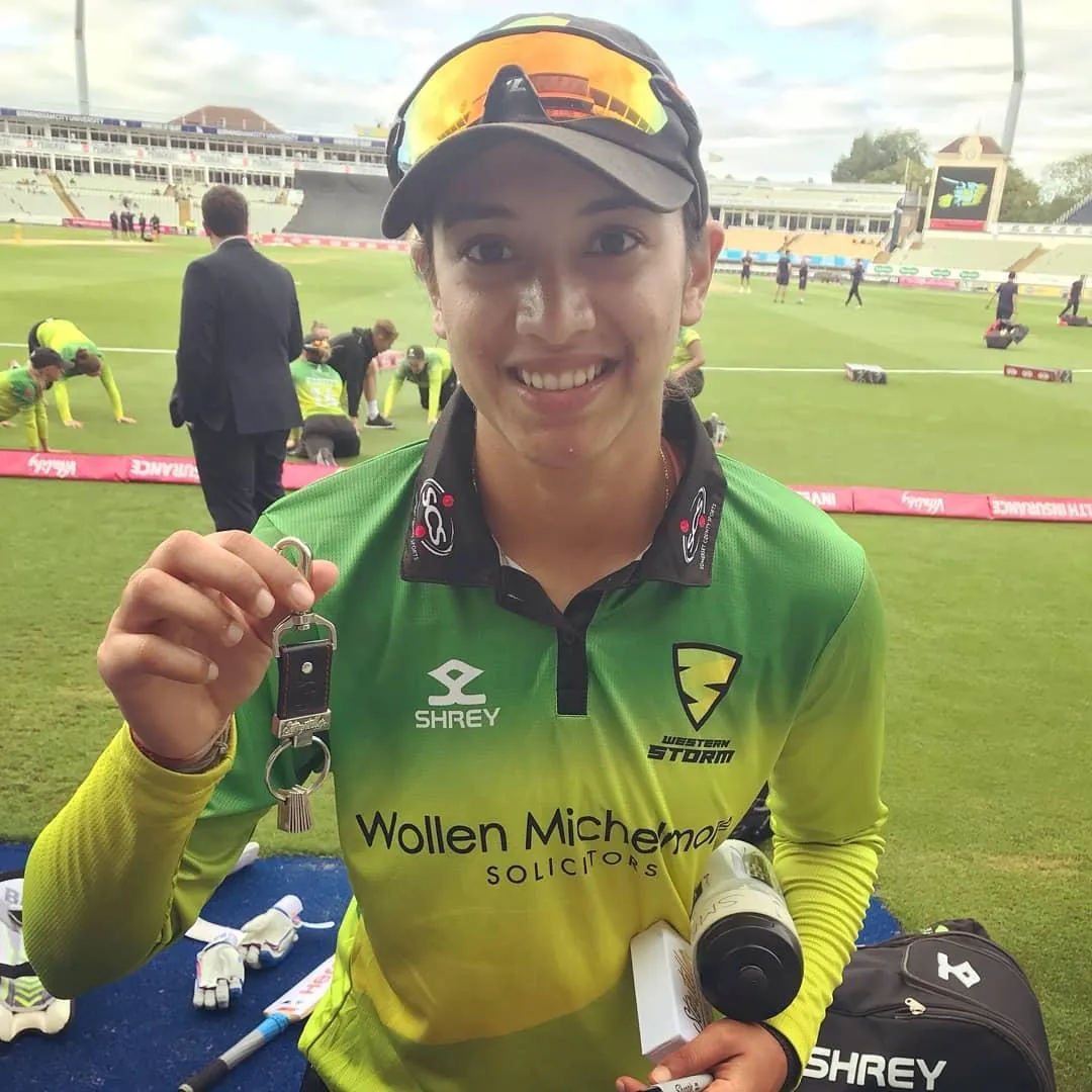 Smriti Mandhana posing with her bat on field wallpaper