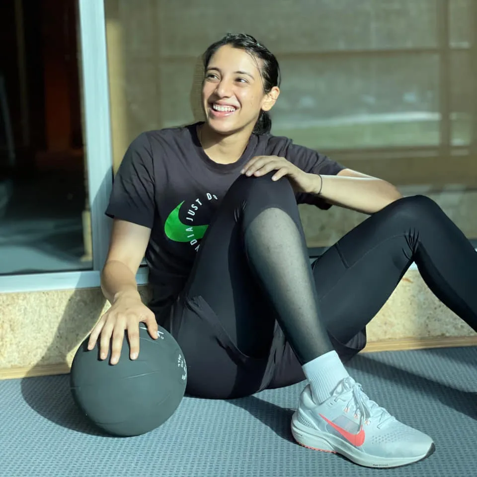 Smriti Mandhana relaxing in a chair while enjoying a moment