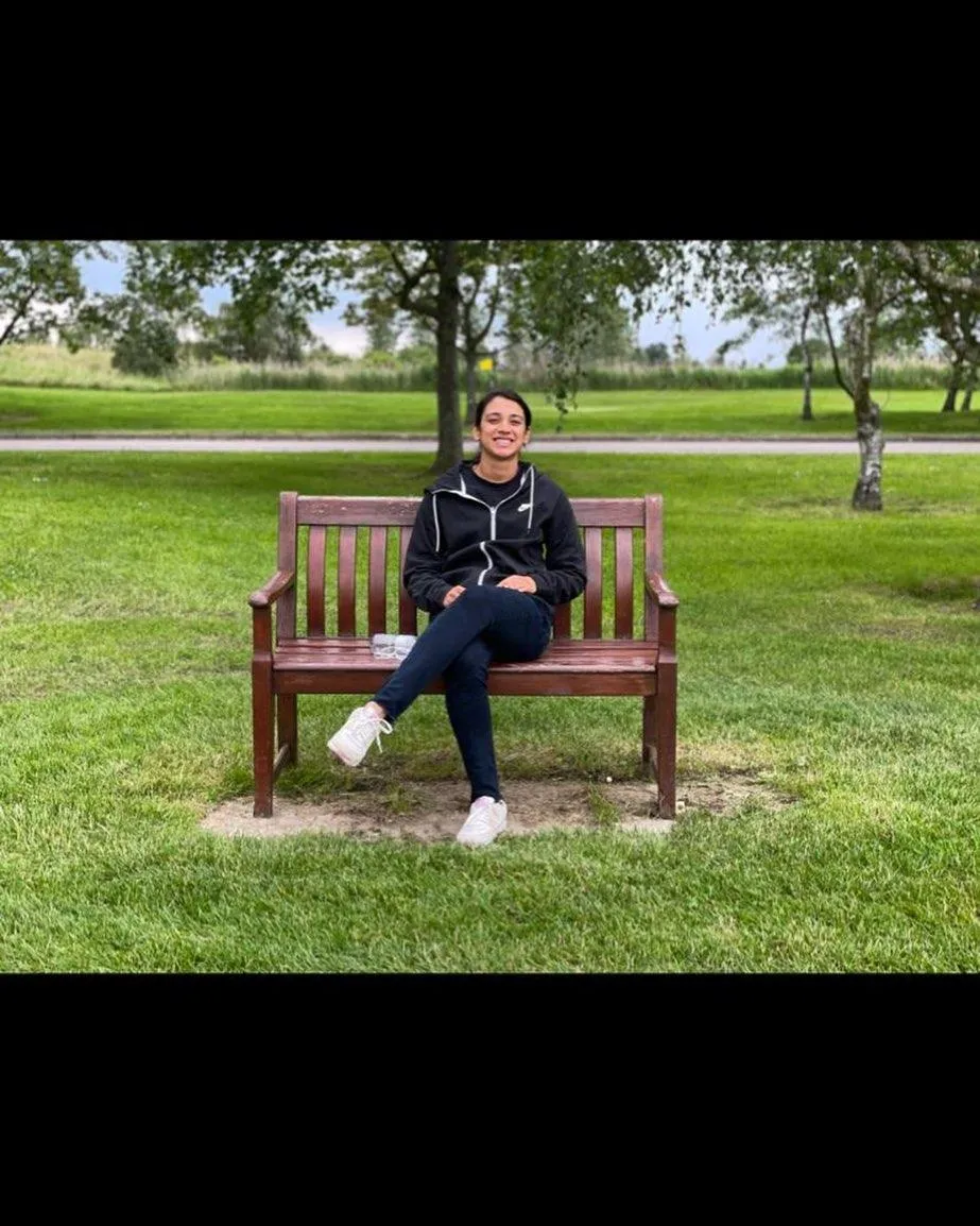 Smriti Mandhana resting on a park bench before a match