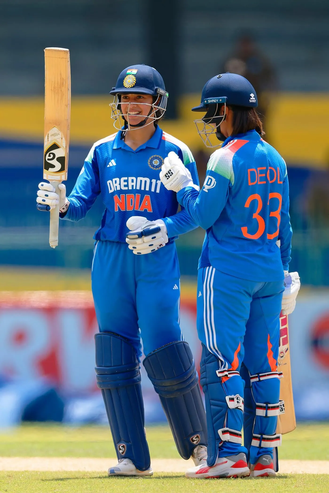 Smriti Mandhana sharing a light moment with a teammate on field