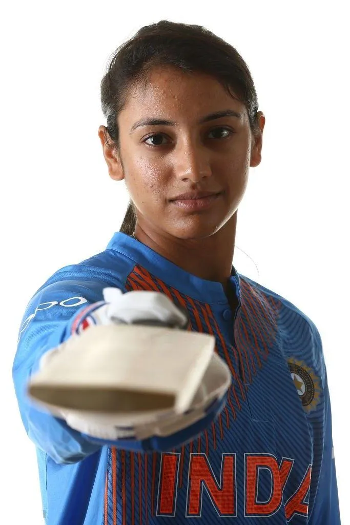 Smriti Mandhana showing cricket shoes in India jersey