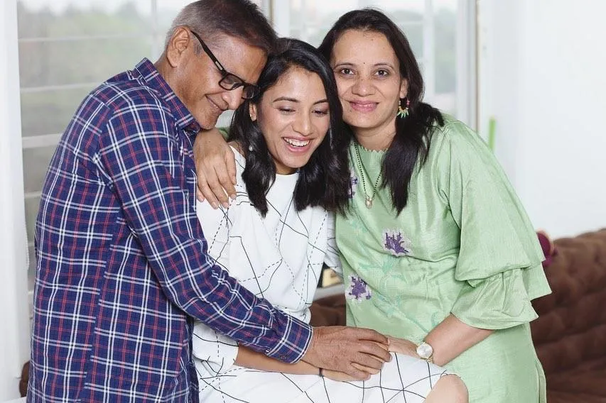 Smriti Mandhana Sitting and Laughing with Family wallpaper
