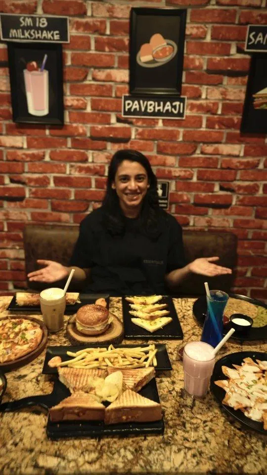 Smriti Mandhana Sitting on Couch with Many Trophies