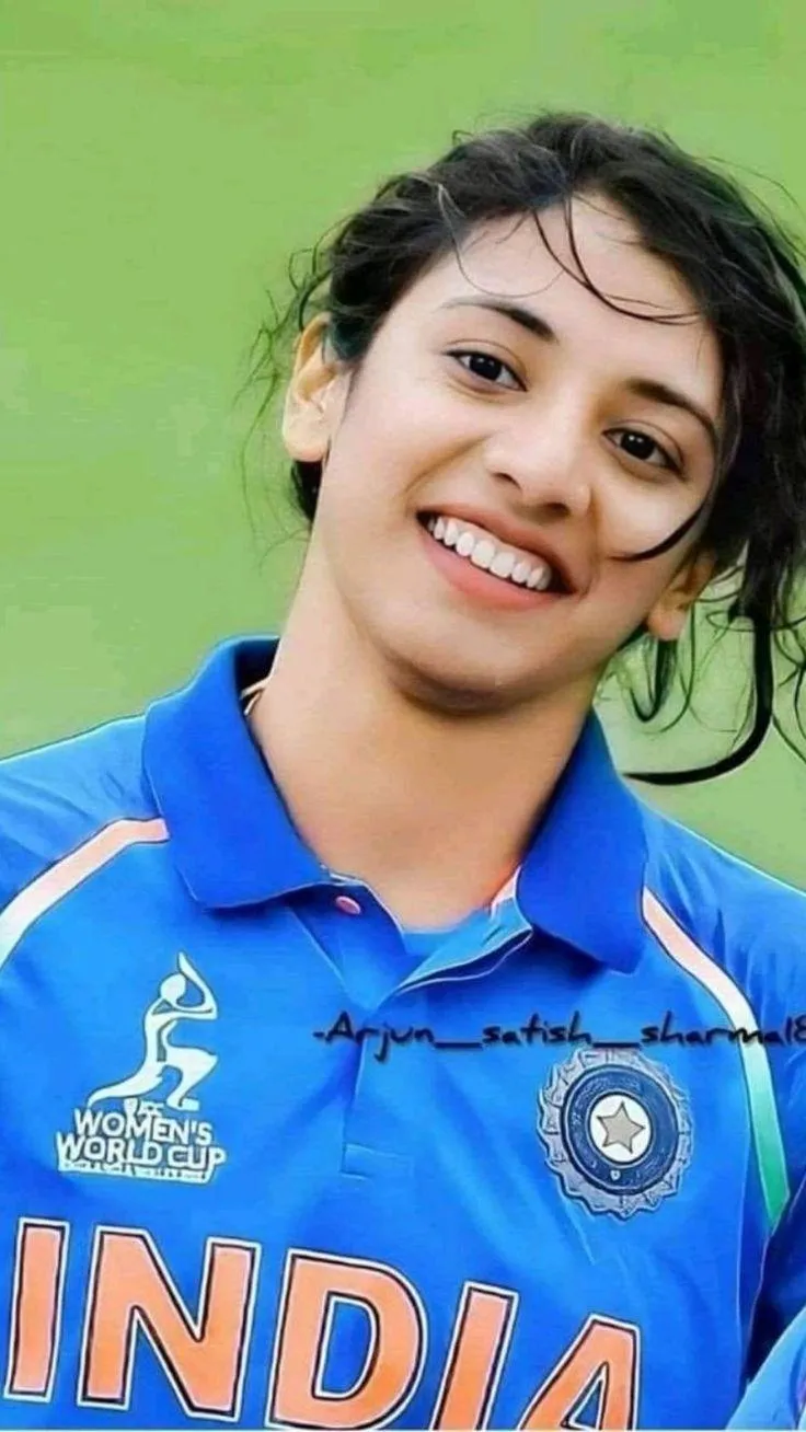 Smriti Mandhana smiling brightly wearing team jersey