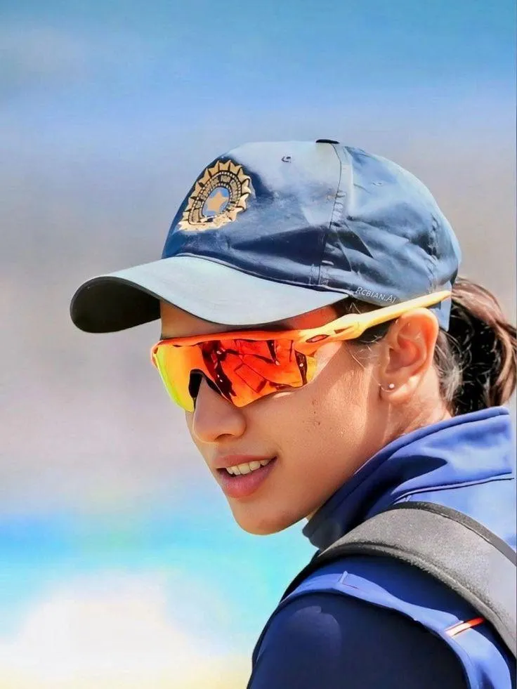 Smriti Mandhana smiling in cap during cricket match