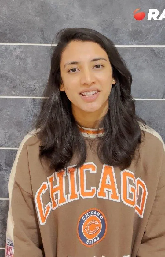 Smriti Mandhana smiling in casual sweatshirt outfit