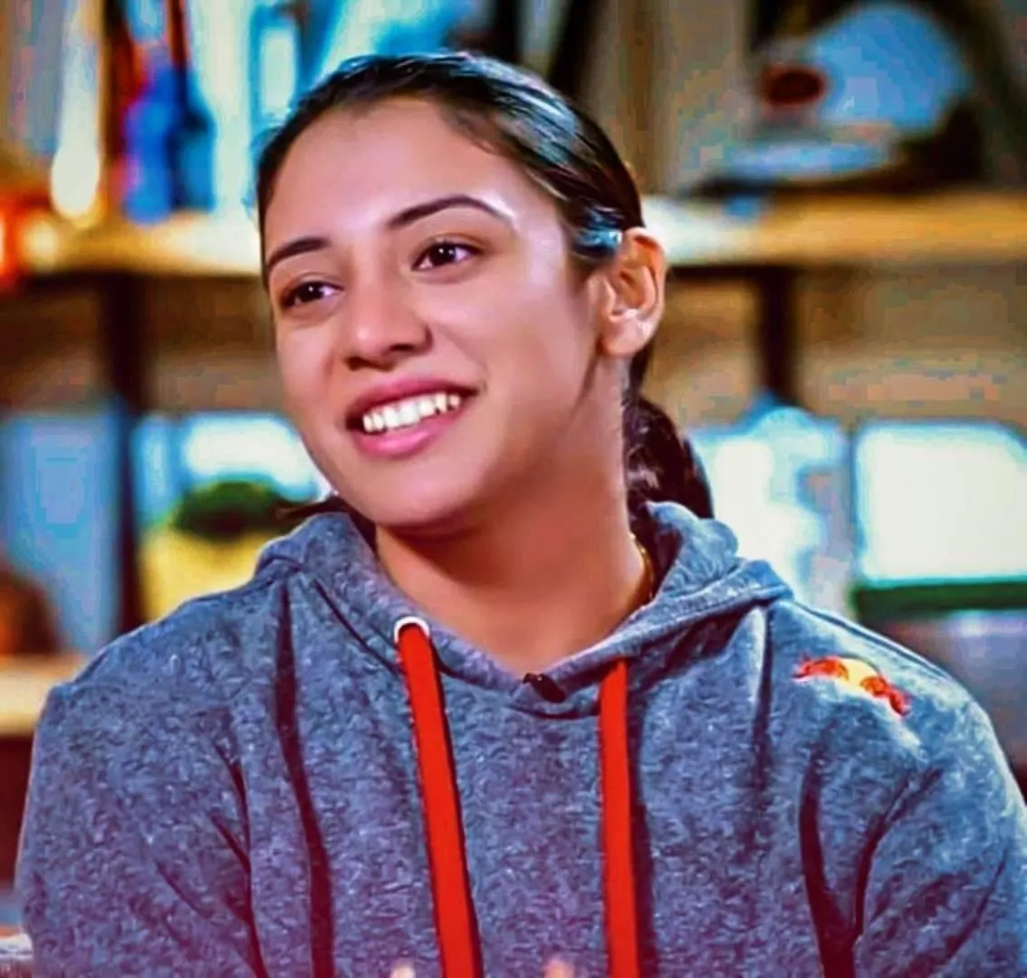 Smriti Mandhana smiling while talking to someone