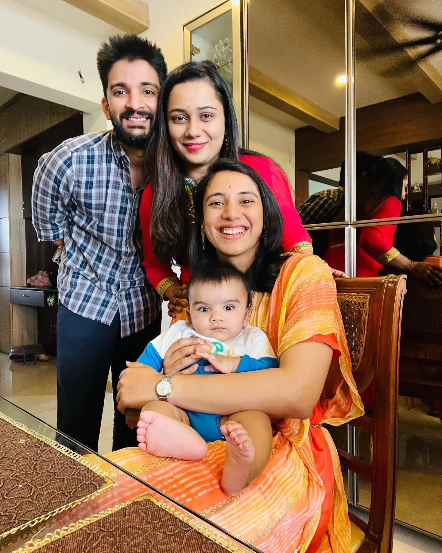 Smriti Mandhana smiling with family in a cozy home setting