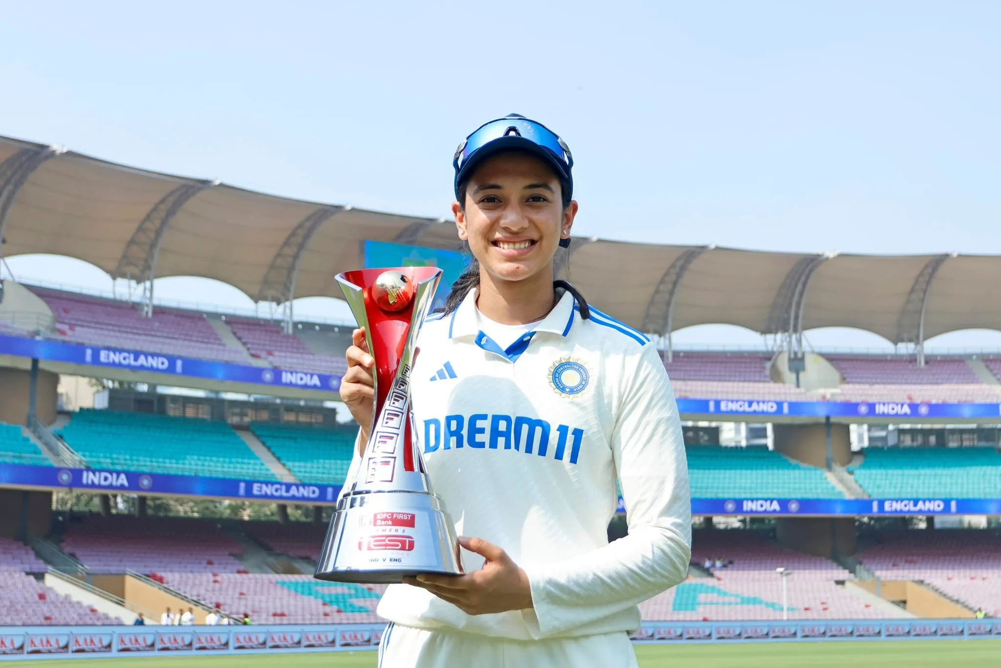 Smriti Mandhana standing by a railing overlooking a scenic view