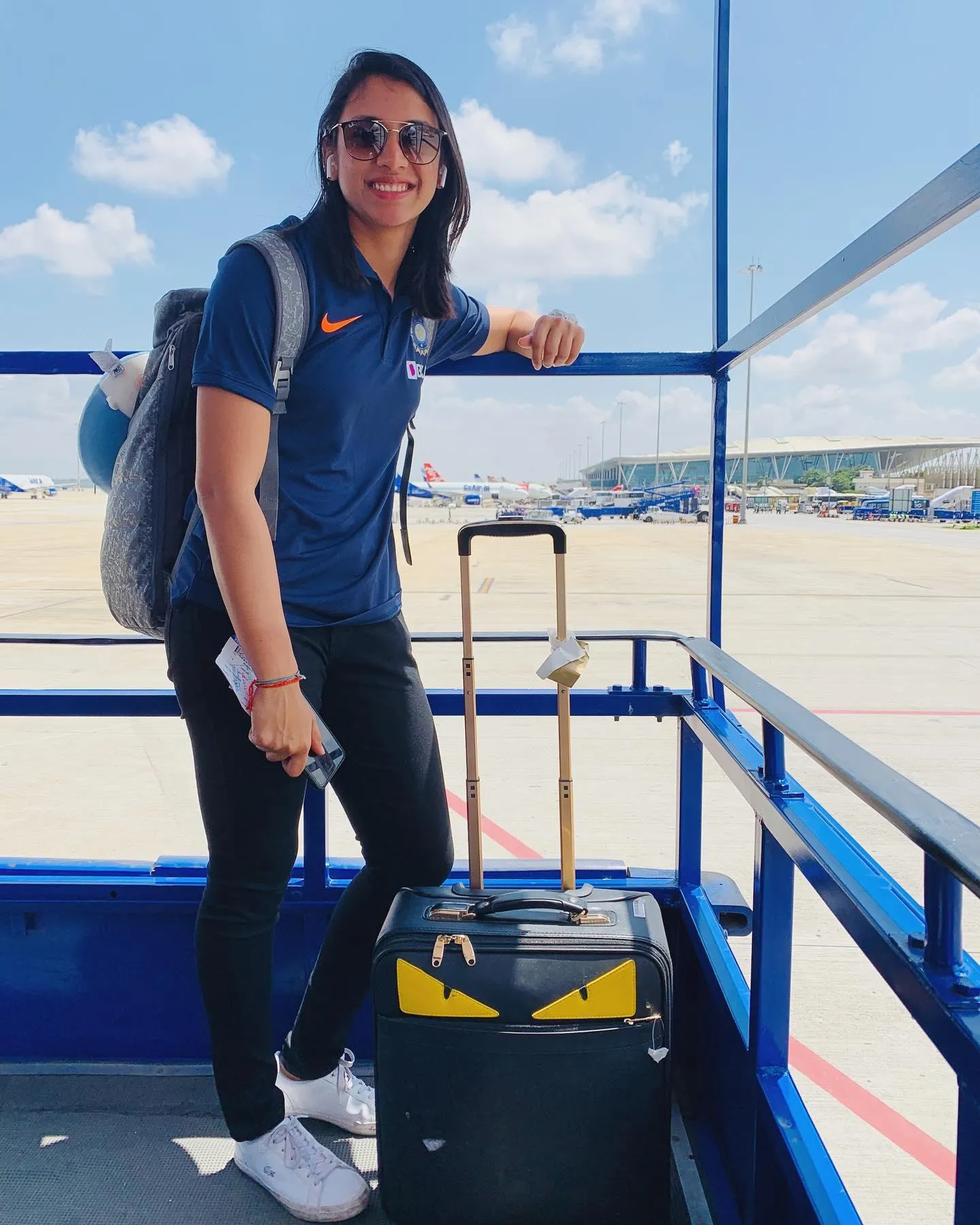 Smriti Mandhana standing on a deck with scenic background
