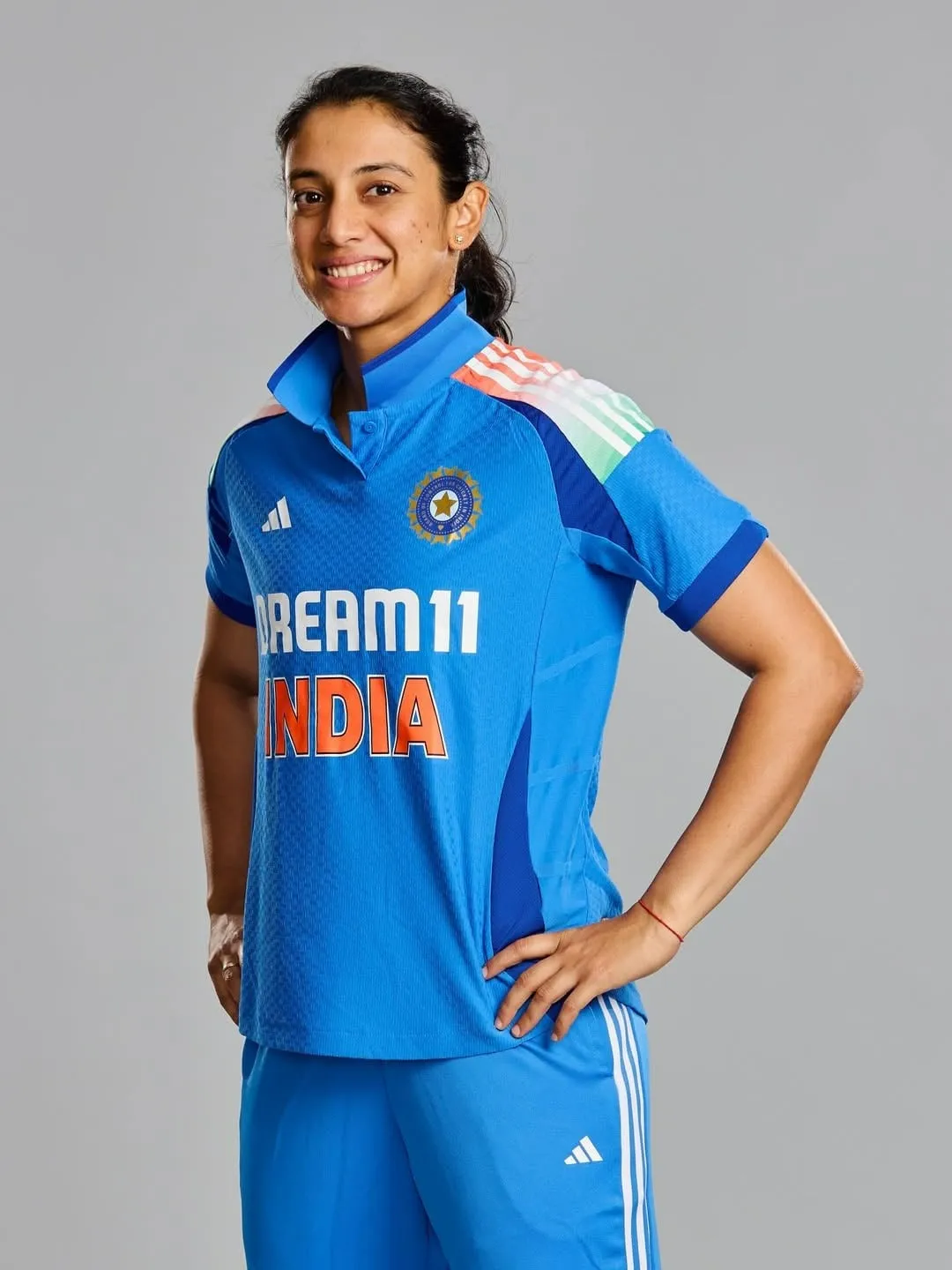 Smriti Mandhana striking a pose in blue Indian jersey