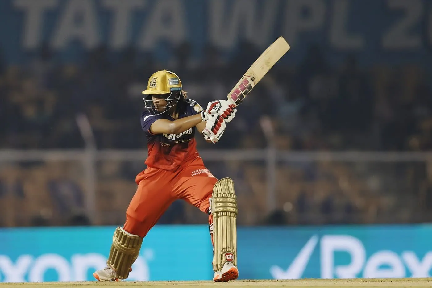 Smriti Mandhana striking a shot in a match wallpaper