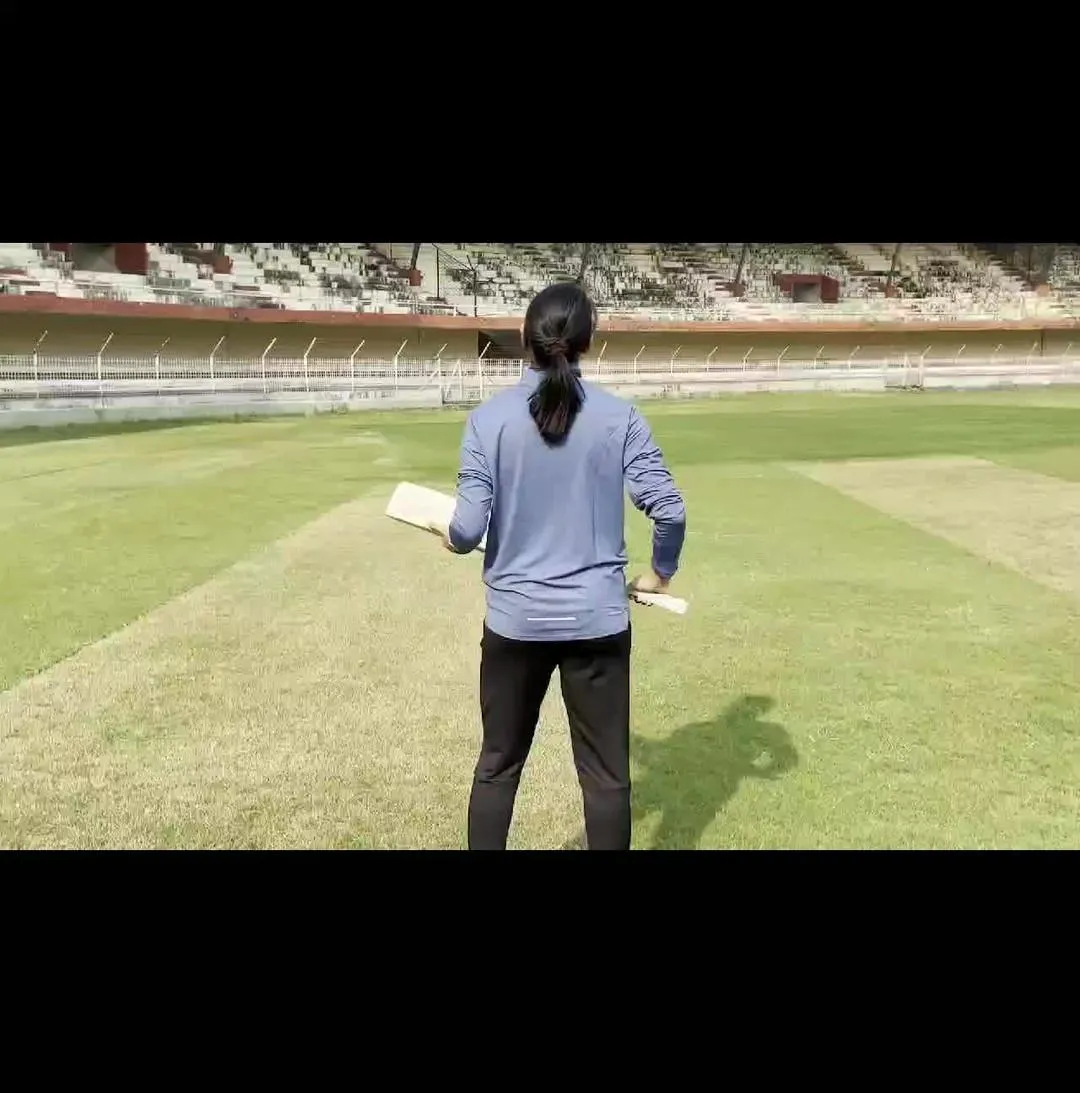 Smriti Mandhana walking on a cricket ground with determination