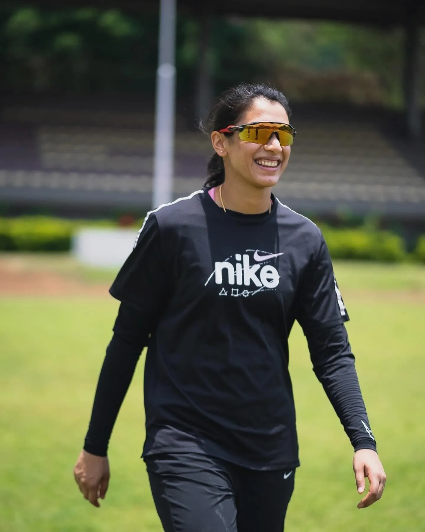 Smriti Mandhana walking on the field dressed for cricket