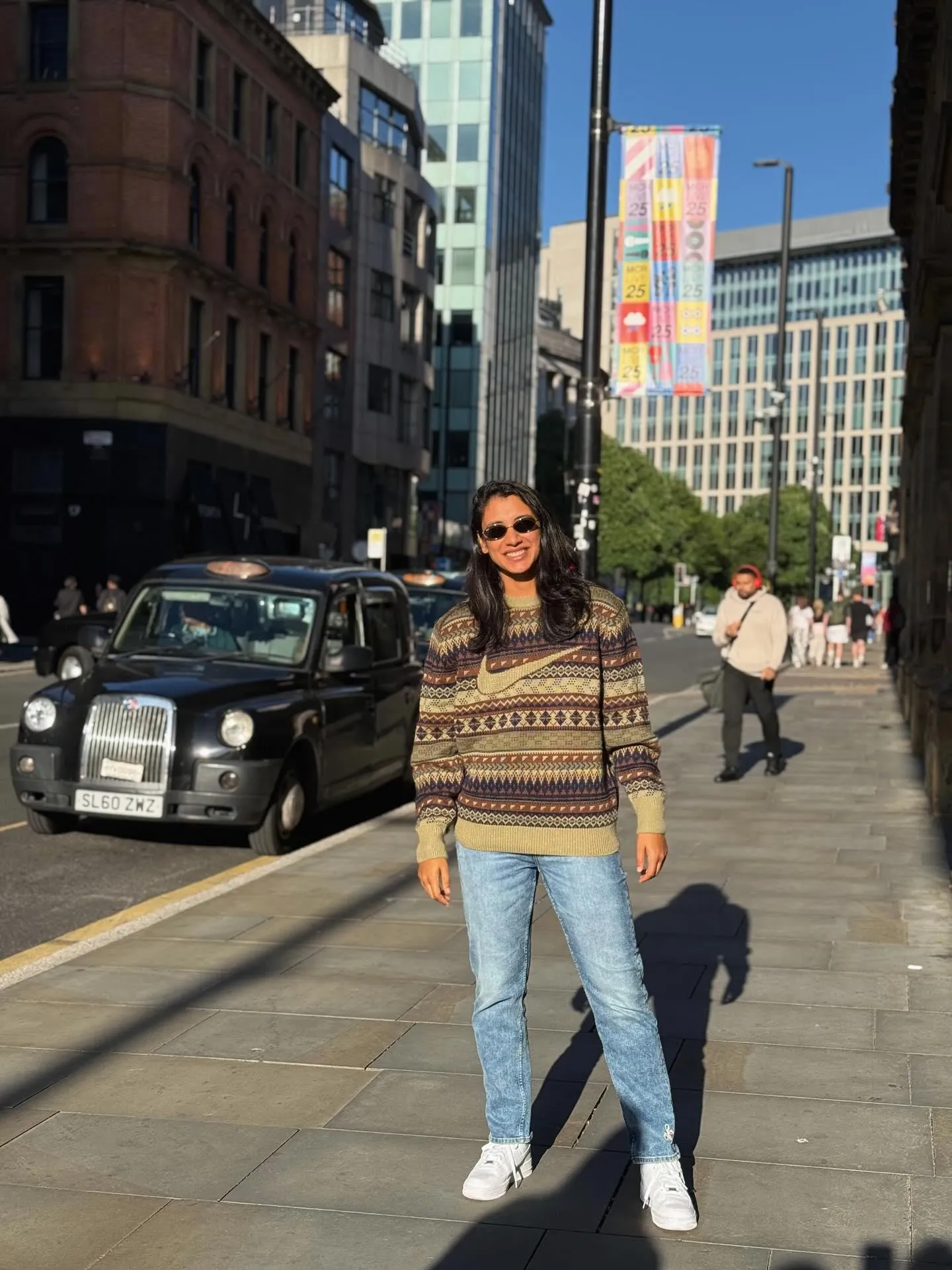Smriti Mandhana walking through a busy urban street