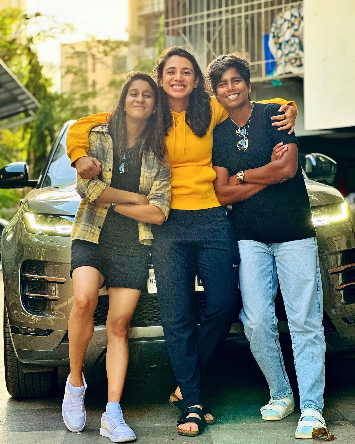 Smriti Mandhana with friends posing by a parked car