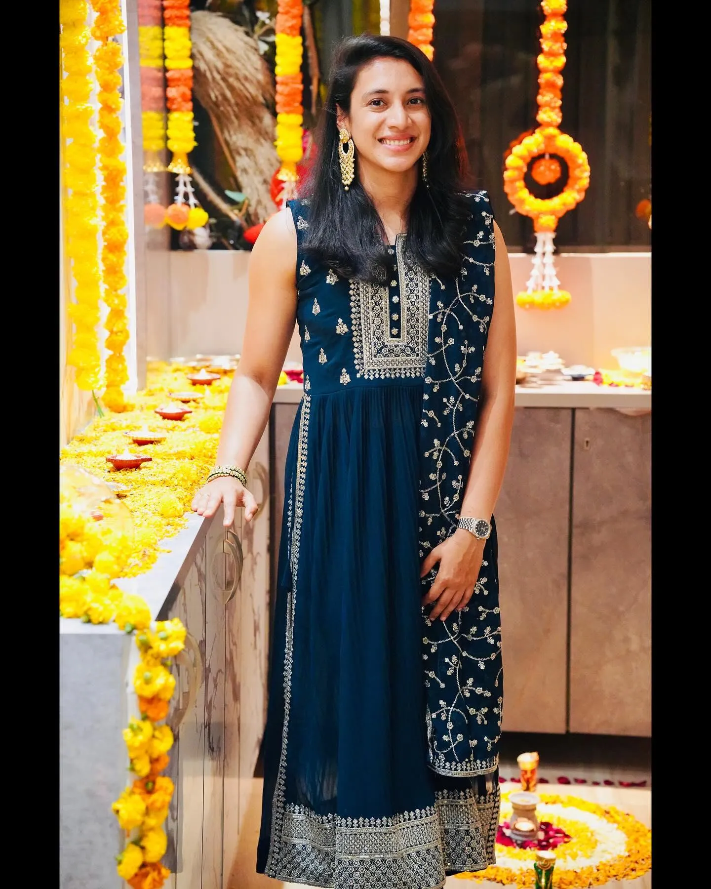 Smriti posing in a long gown with lights and decor
