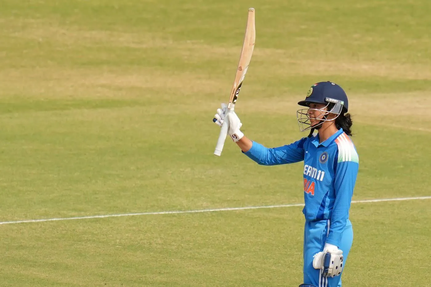 Smriti Raising Bat After Scoring Runs in Cricket Match