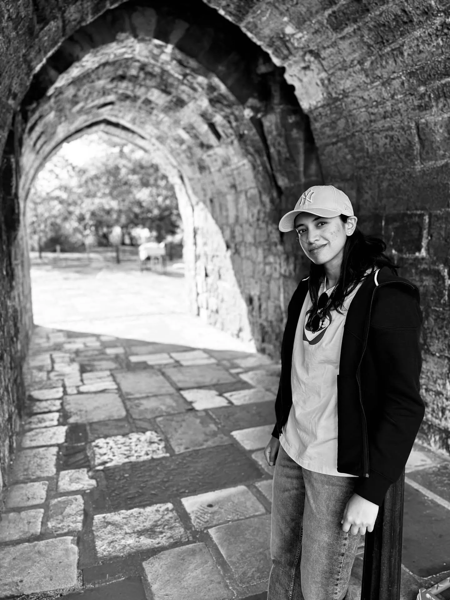 walking through an ancient stone arch in black white