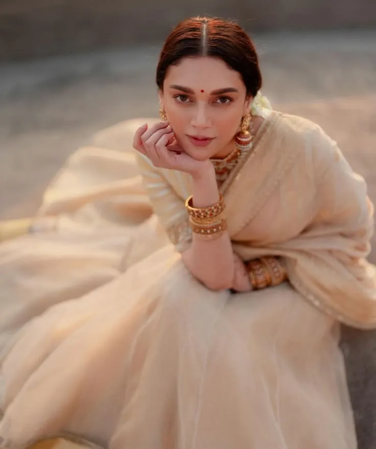 Aditi Rao Hydari in a Kasavu saree sitting on the floor