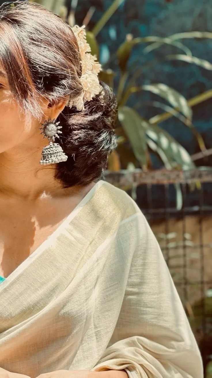 Aesthetic saree pose of a woman wearing a kasavu saree