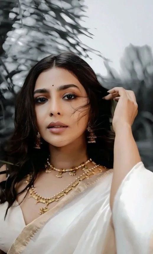 Aishwarya Lekshmi in a hot white saree looking at the camera
