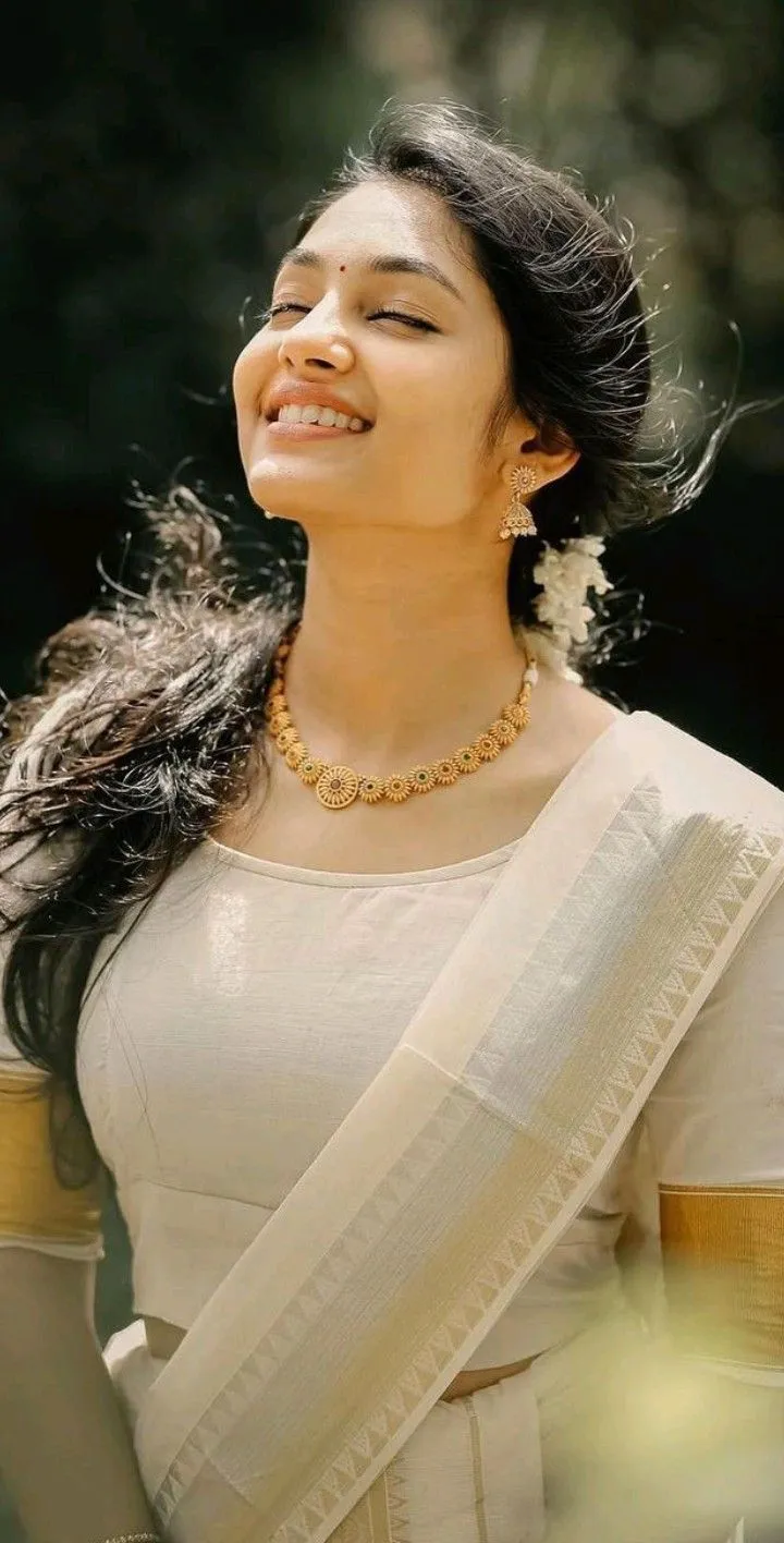 Aleena Shaji in a white saree with eyes closed pose image