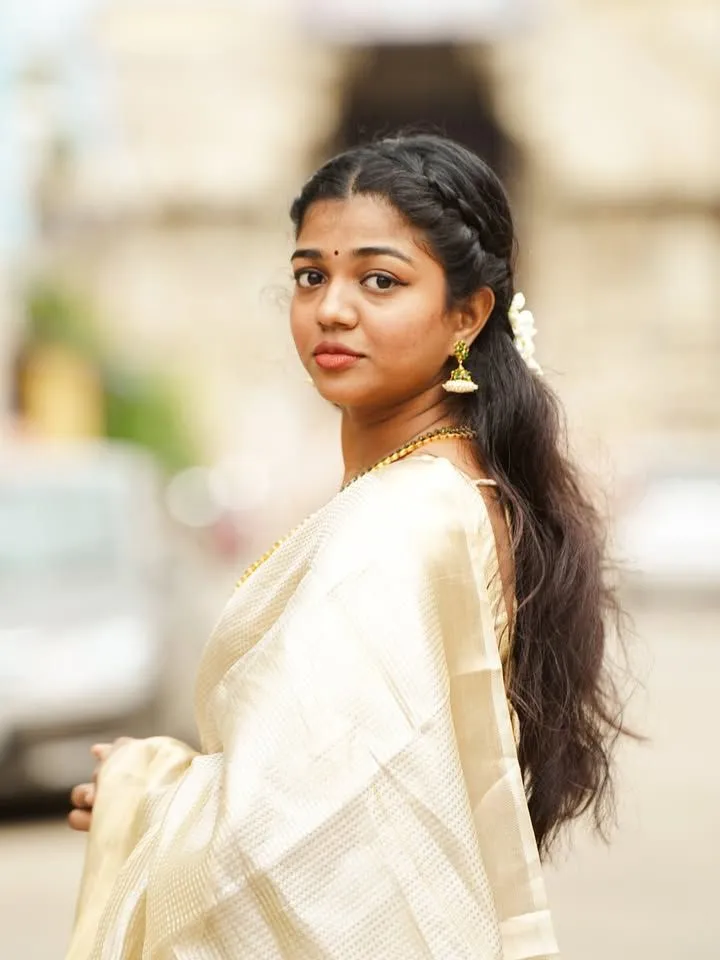 Amala Shaji in a classy Onam saree looking at the camera