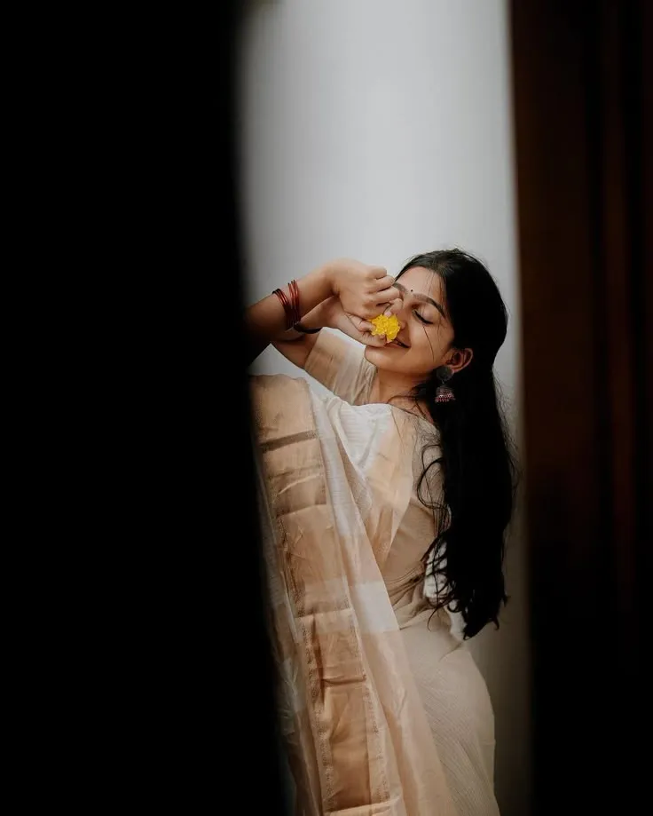 Ananthika Sanilkumar in Nerial saree smelling yellow flower