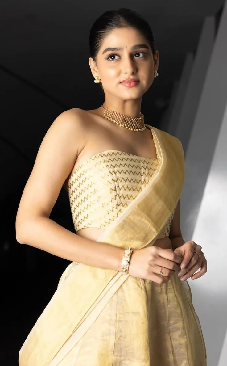 Anaswara Rajan in a glamorous ethnic wear near the wall