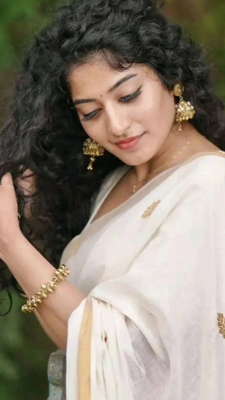 Anjali Nair in a Kasavu saree standing in a side pose image