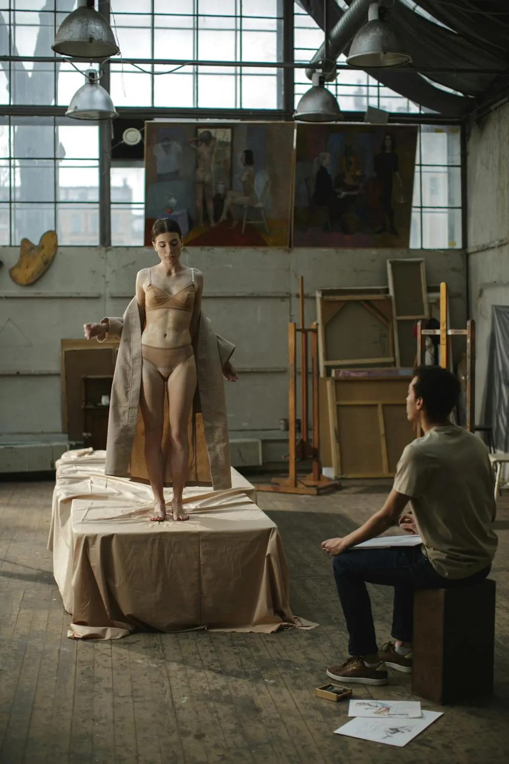 Artist Sketching a Model Posing in a Bright Spacious Studio