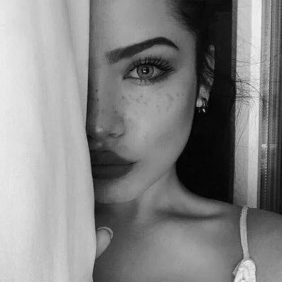 Artistic Black and White Image of a Woman Behind Curtains